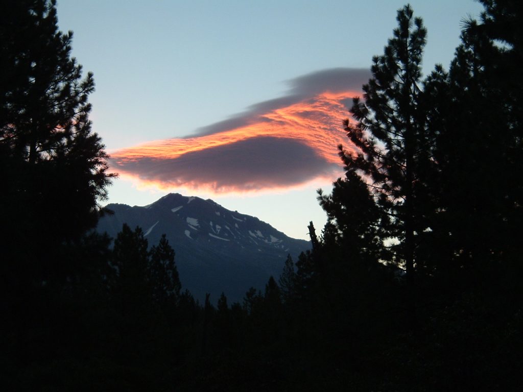 mt. shasta/wyeka mountain from the land at ravensites at sunrise with a lenticular cloud with pink highlight symbolizing that new beginnings and a return to life can linger like a lenticular cloud which exists because of a mighty mountain
